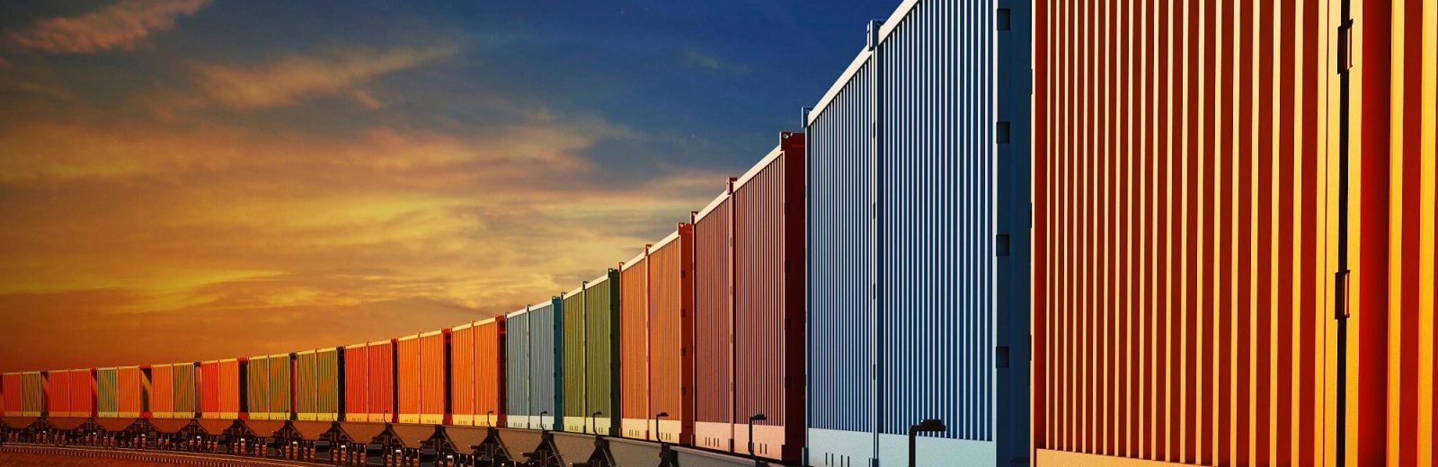 A train of multi-coloured containers curving into the distance with an orange sunset