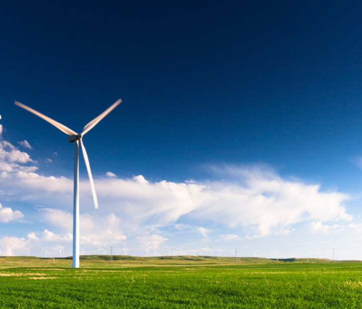 A single wind turbine against a blue sky backdrop