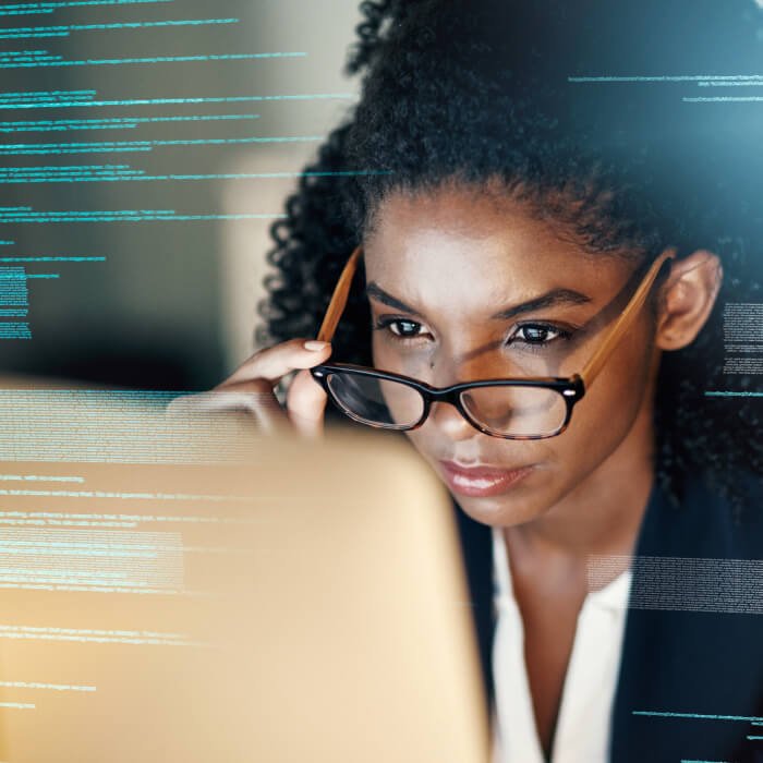 Image of a woman working at a laptop overlaid by data graphics