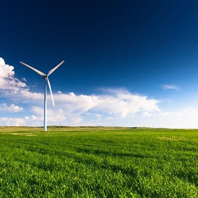wind turbines in a field with deep blue sky