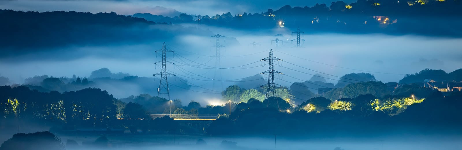 electricity pylons in the mist at dusk
